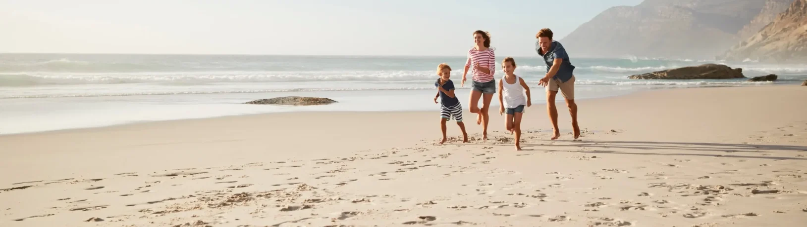 Familie am Strand: Eine gut ausgestattete Reiseapotheke sollte im Urlaub nie fehlen